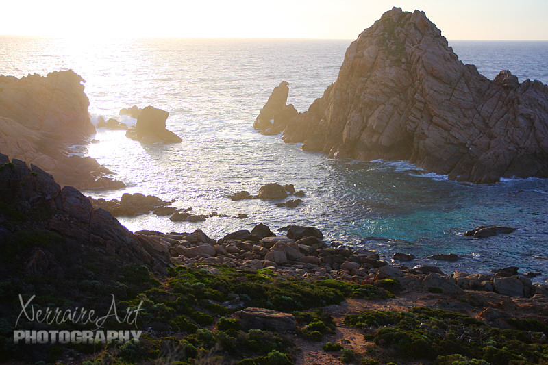 And here it is the rock they call Sugarloaf, surrounded by amazing turquoise waters, rocks, sea foam, and a bright setting sun with sea spray.