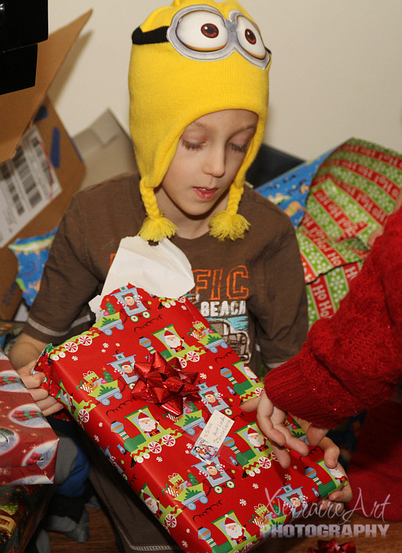 Silas amongst the presents and so cute in his hat.