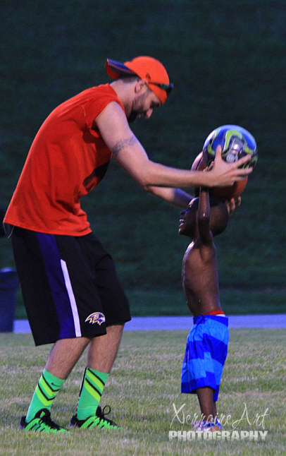 Miquel plays soccer with a little friend.