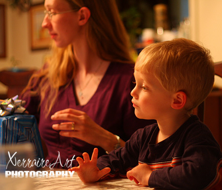 Silas is trying to look interested in the presents but the cake is calling him.