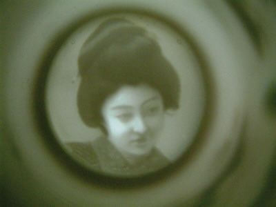 geisha at bottom of tea cup